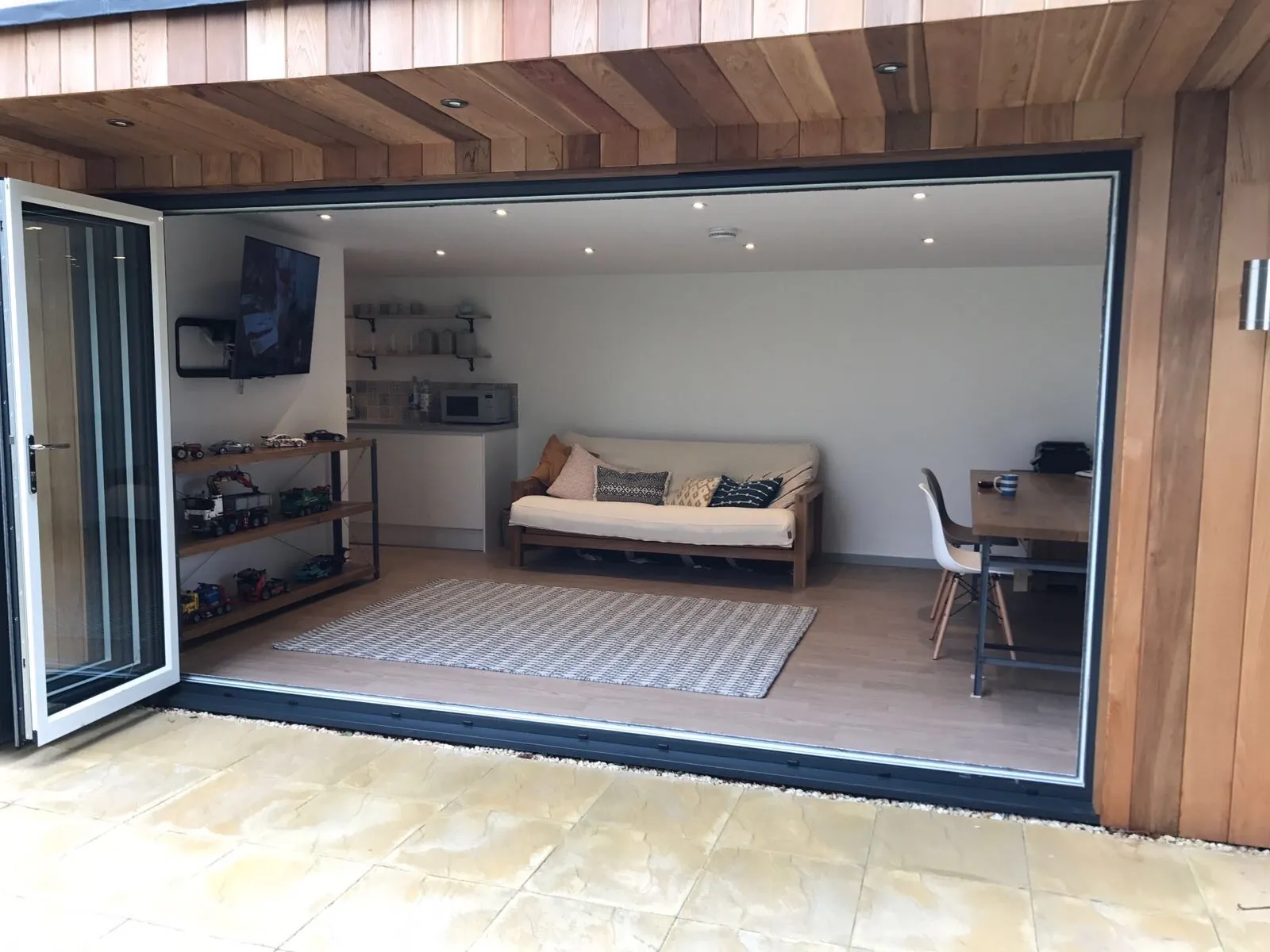 Inside a finished garden office, seen through its open bi-folding doors